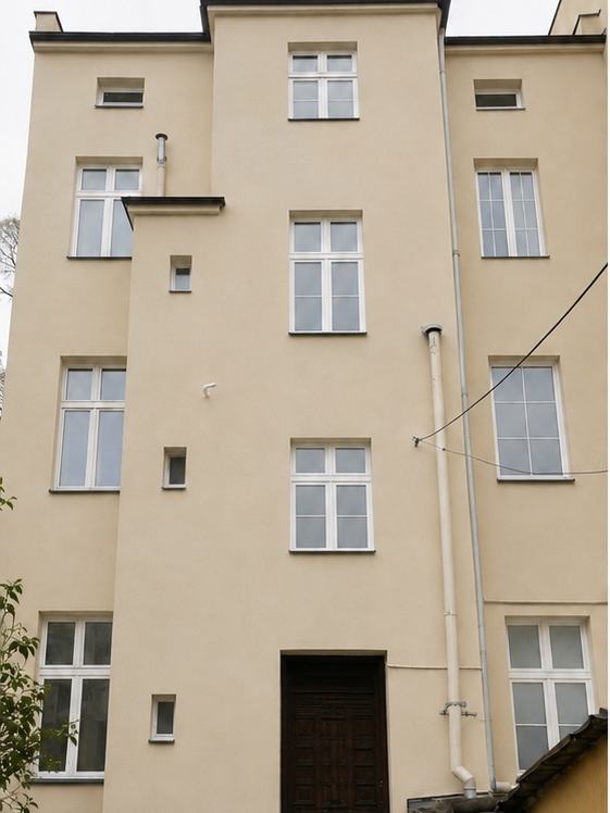 Ta sama kamienica po rewitalizacji — nowy tynk, wymieniona stolarka, uporządkowane podwórze