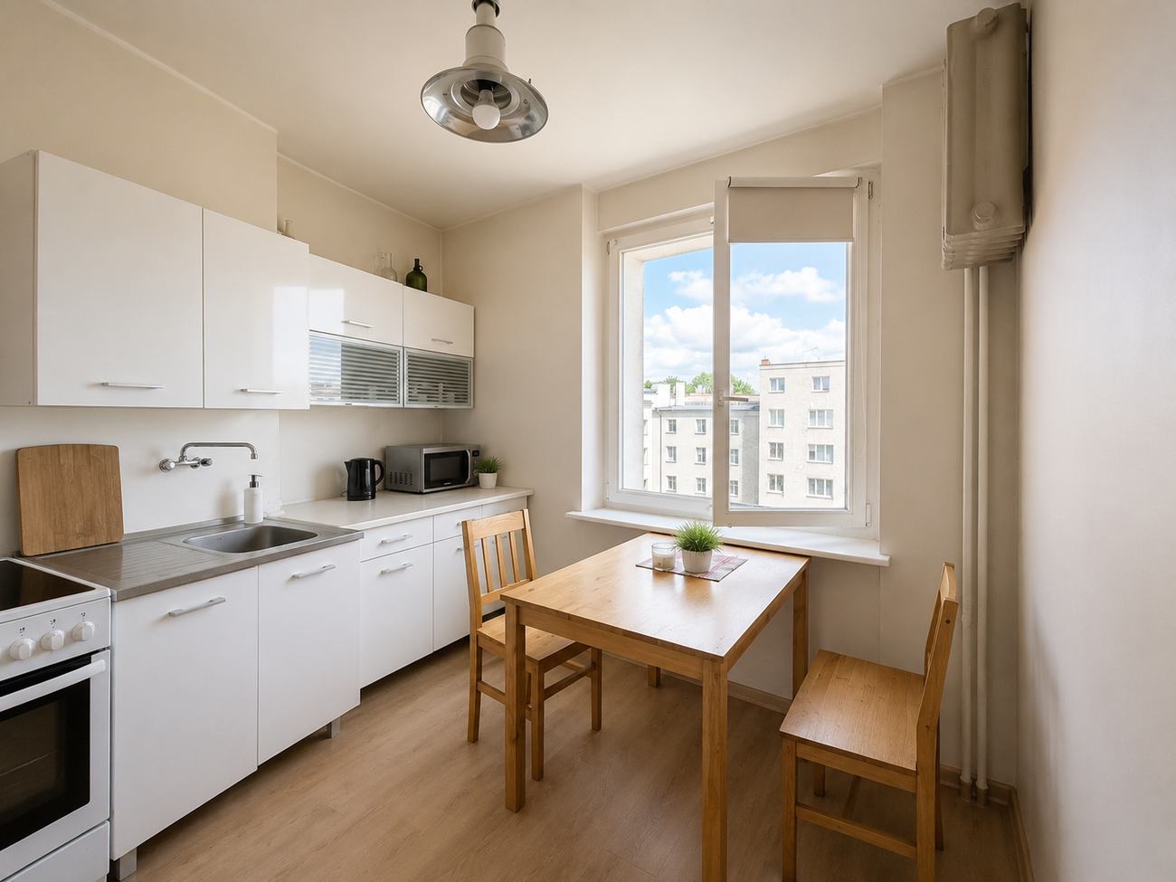 Ta sama kuchnia po home stagingu — pusty blat, jeden akcent na stole